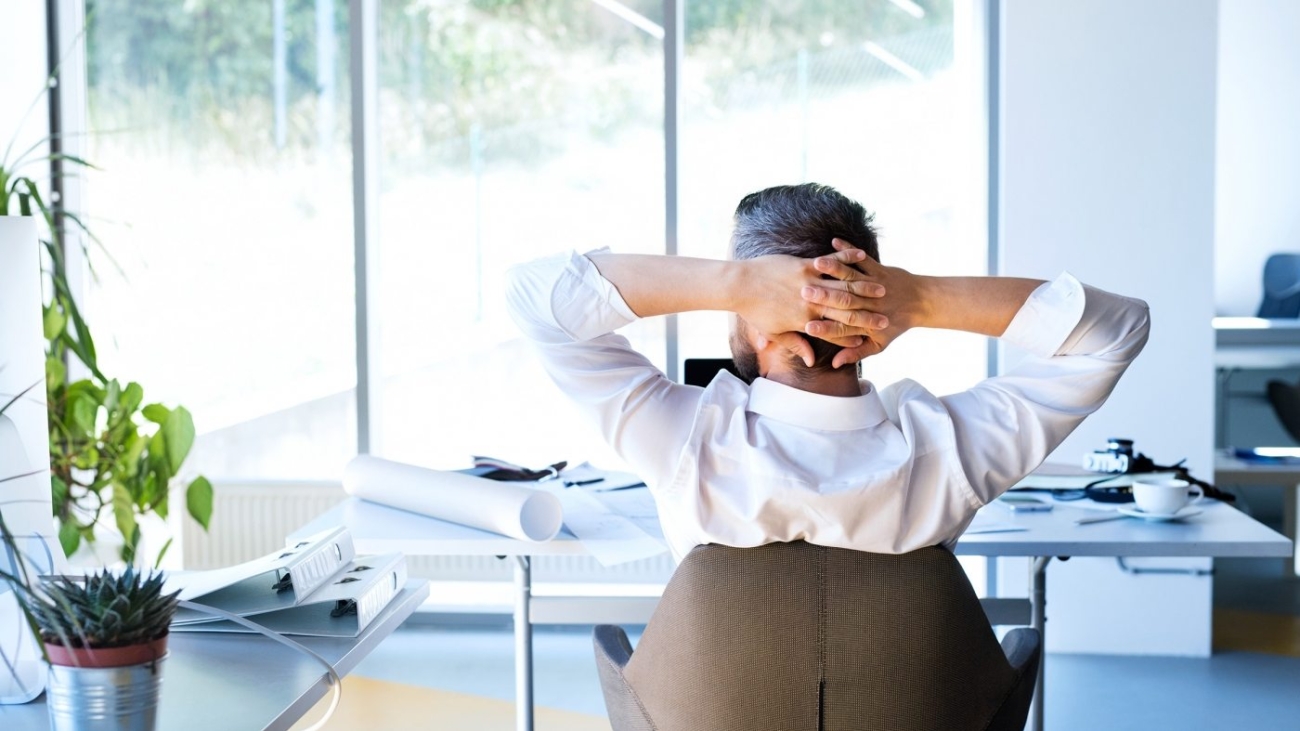 Businessman-at-the-desk-in-his-office-resting.-1400x788